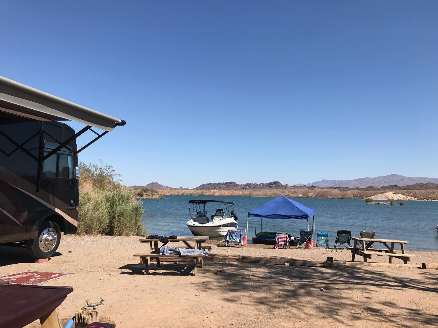 Motorhome and boat parked at a desert lake